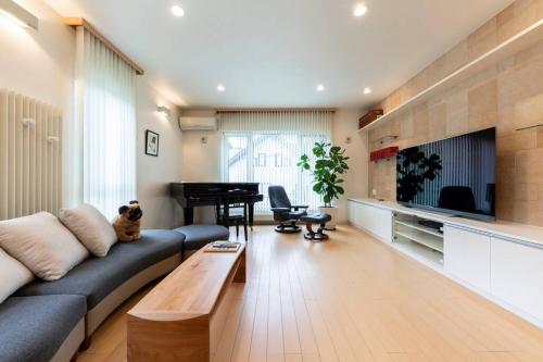 a living room with a couch and a piano at The Casa Azucena in Sapporo