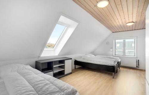 a bedroom with a bed and a desk and a window at Det gamle forsamlinghus in Struer