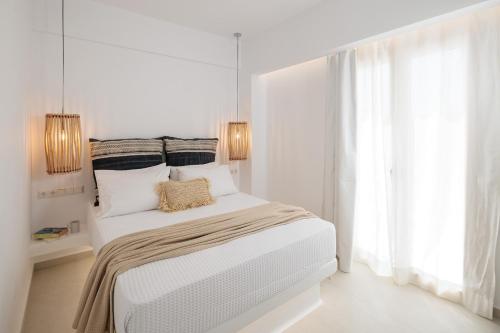a white bedroom with a bed and a window at Country Villas in Stelida