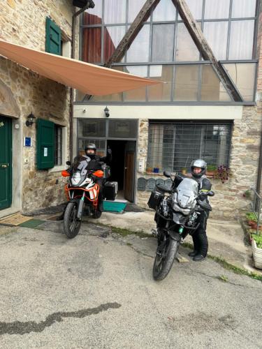 two people on motorcycles parked in front of a building at La Corte dei Celti La fonte in San Benedetto Del Querceto
