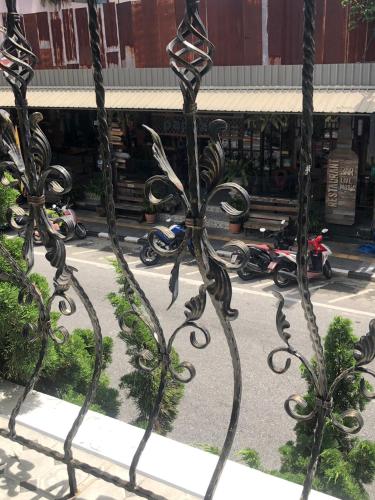a metal fence with scooters parked in a parking lot at Casa Blanca Boutique Hotel - SHA Plus in Phuket Town