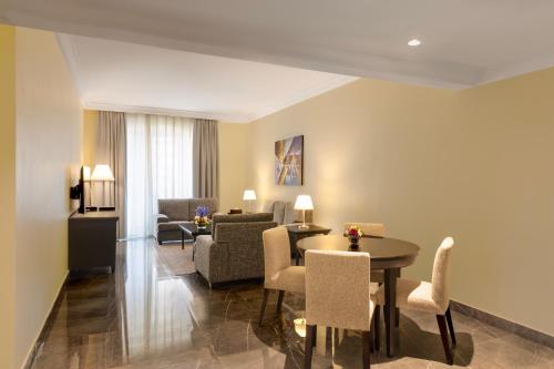 a living room with a table and chairs at Dream City Hotel Apartments LLC in Dubai