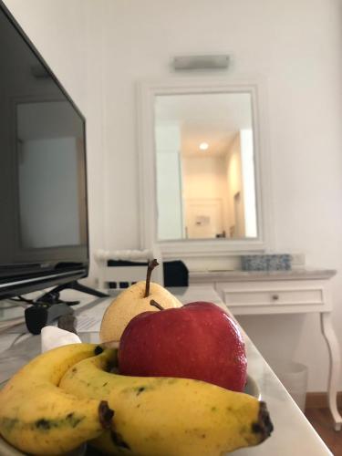 an apple and two bananas on a table with a television at Casa Blanca Boutique Hotel - SHA Plus in Phuket Town