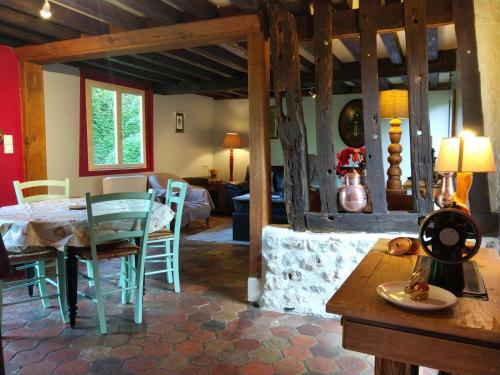 une salle à manger et un salon avec une table et des chaises dans l'établissement Maison à la campagne, à Courtonne-la-Meurdrac