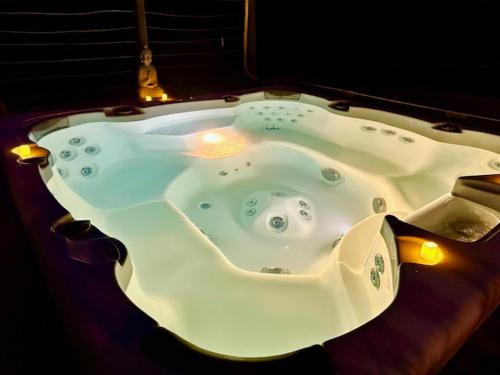 una gran bañera blanca con luces en una habitación en Chalet Chevreuil avec accès jacuzzi en Lucéram