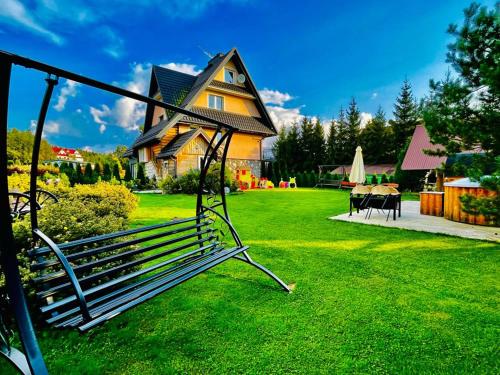 a swing in front of a house with a yard at Sauna-balia-Apartamenty Góraleczka II in Czarna Góra
