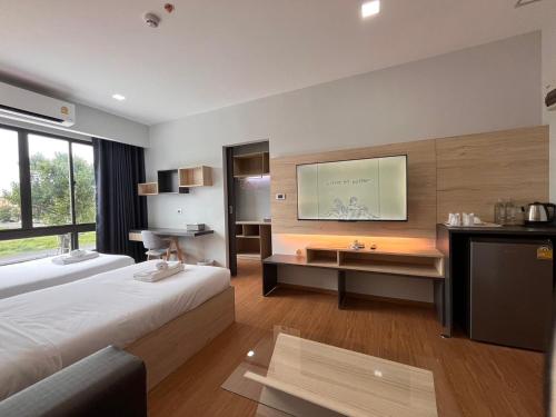 a hotel room with a bed and a television at JIA HAUS Hotel Apartment in Buriram