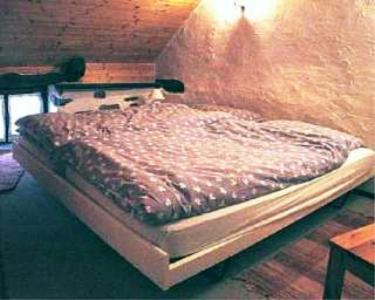 a bed in the corner of a room at Rustico Il Nido in Maggia