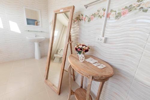 a bathroom with a mirror and a table with flowers at BB&B Hotel in Fang