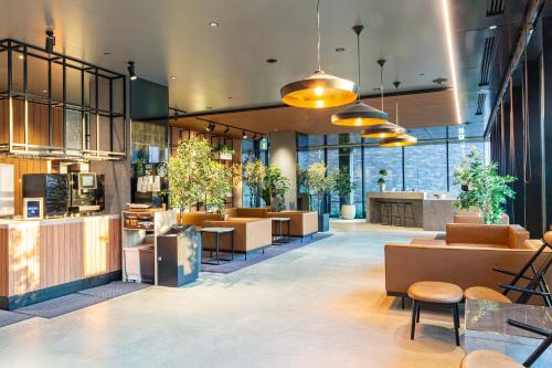 a lobby of a restaurant with tables and chairs at Hotel Keihan Namba Grande in Osaka