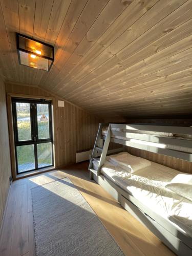 a large room with two bunk beds and a window at Geilo - Ny og flott hytte på budalstølen in Geilo