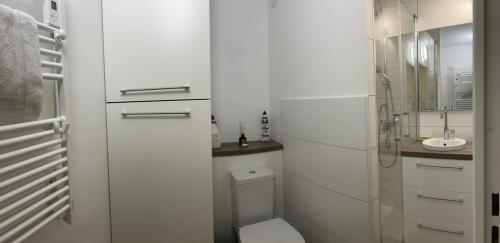 une salle de bain blanche avec des toilettes et un lavabo dans l'établissement Appartement T3 Vue Mer La Corniche Sète, à Sète