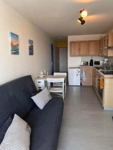 un salon avec un canapé et une cuisine dans l'établissement Appartement T3 Vue Mer La Corniche Sète, à Sète