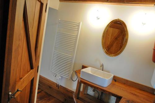 a bathroom with a sink and a mirror on the wall at Le Presbytère in Soy