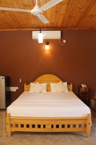 a bedroom with a large bed with white sheets at Bluewater Beach Resort in Trincomalee