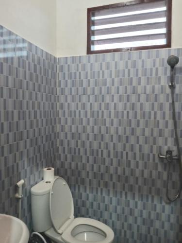a bathroom with a toilet and a sink and a shower at marbun in Tuk Tuk