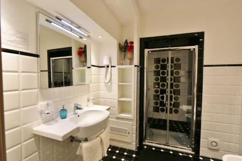 y baño blanco con lavabo y ducha. en Residenza Adriana, en Roma