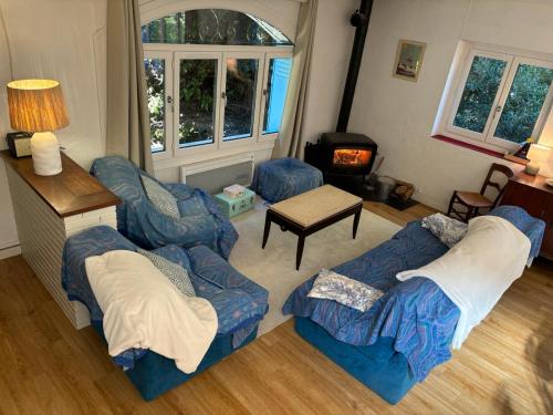 - un salon avec deux canapés bleus et une cheminée dans l'établissement La Huchette,Votre Refuge d'Hiver, à Ax-les-Thermes