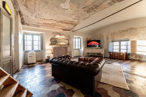 a living room with a leather couch in a room at Palazzo Boyl 1840 in Cagliari