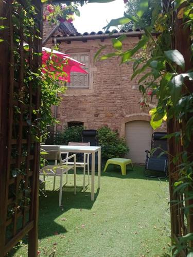 une terrasse avec une table blanche et un parasol rose dans l'établissement Astrid et Pierre-Antoine, à Cluny