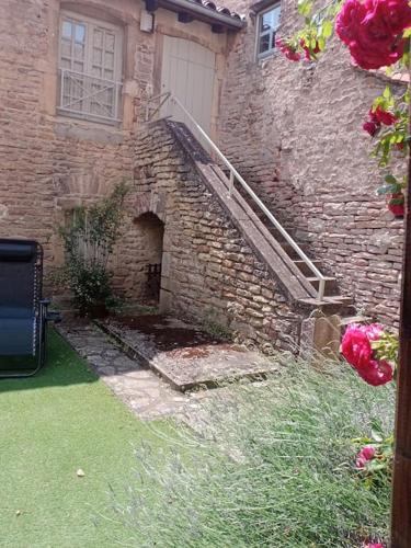 - un bâtiment en pierre avec un escalier à côté d'une porte dans l'établissement Astrid et Pierre-Antoine, à Cluny