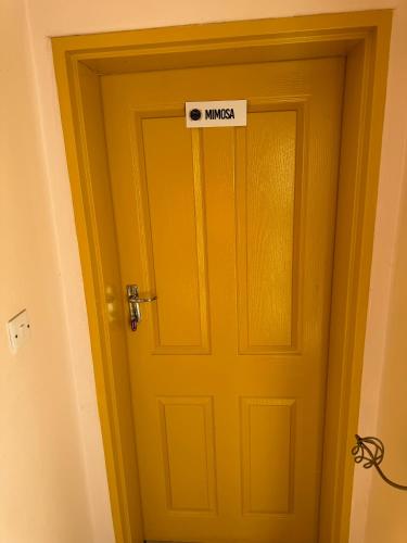 a yellow door with aunless sign on it at Pomona BB House in Harare
