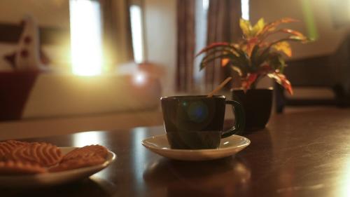 a cup of coffee and a plate of food on a table at Hotel Mountview Comforts in Tirupati