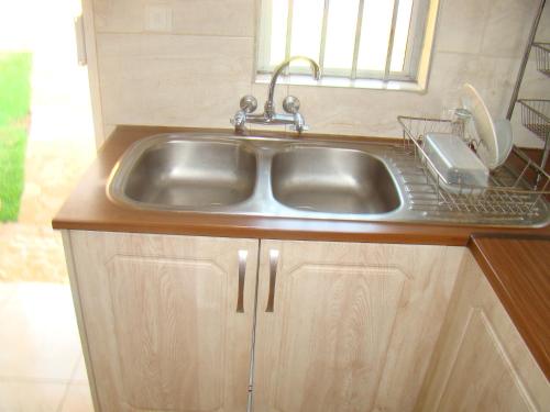 a stainless steel sink in a kitchen with a window at Pomona BB House in Harare