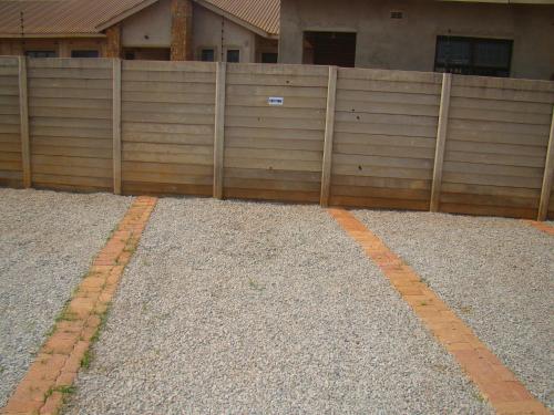 a wooden fence in front of a house at Pomona BB House in Harare