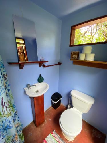 a bathroom with a white toilet and a sink at Rancho Burica in Pavones