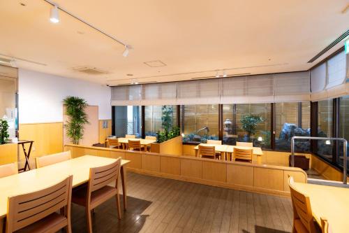 a dining room with tables and chairs and windows at Onomichi Kokusai Hotel in Onomichi