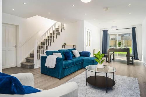 a living room with a blue couch and a piano at Spacious 4Bed Home, Sleeps 10, Pool Table, Parking, Perfect For Groups in Manchester