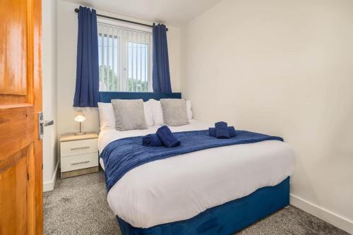 a bedroom with a blue and white bed with a window at Spacious 4Bed Home, Sleeps 10, Pool Table, Parking, Perfect For Groups in Manchester