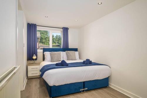 a bedroom with a blue and white bed and a window at Spacious 4Bed Home, Sleeps 10, Pool Table, Parking, Perfect For Groups in Manchester