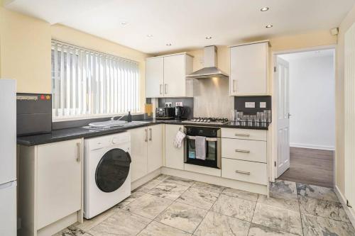 a kitchen with white cabinets and a dishwasher at Spacious 4Bed Home, Sleeps 10, Pool Table, Parking, Perfect For Groups in Manchester