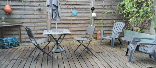 a group of chairs and an umbrella on a deck at La grange du Manemeur in Quiberon
