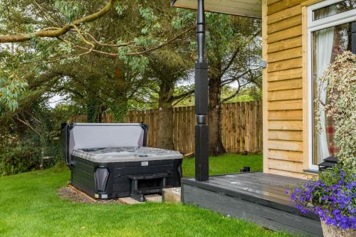 a barbecue grill sitting on the porch of a house at Hunters Glebe Lodge in Castlerock