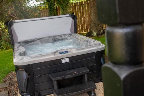 a hot tub sitting on top of a grill at Hunters Glebe Lodge in Castlerock