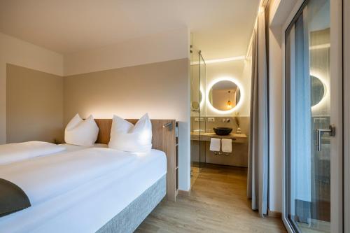 a hotel room with a bed and a bathroom at Hotel Hubertus in Sankt Johann im Pongau