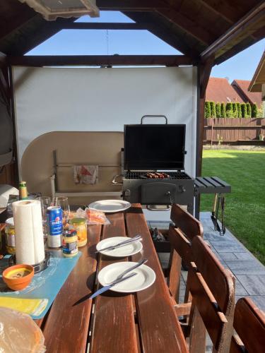 a picnic table with a grill in a backyard at Tatraview House in Veľká Lomnica