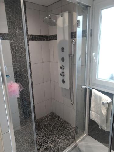 une salle de bain avec une douche avec une porte vitrée dans l'établissement Chambre Grand lit Afrik, à Combs-la-Ville
