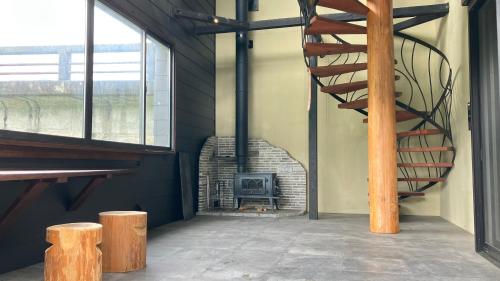 a room with a brick fireplace and a staircase at Hanno Base -飯能ベース- in Hanno