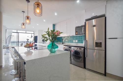 una cocina con nevera y un jarrón de flores en un mostrador en Simla Luxury Apartments 11, en Margate
