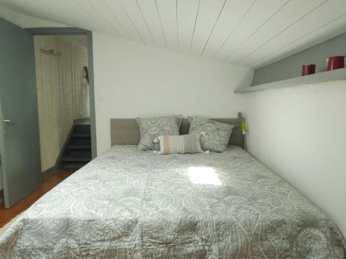 - une chambre avec un lit et une couette grise dans l'établissement Maison 4 personnes Port La Flotte, à La Flotte