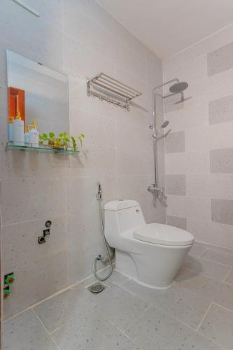 a white bathroom with a toilet and a shower at Rio 02 homestay in Vung Tau