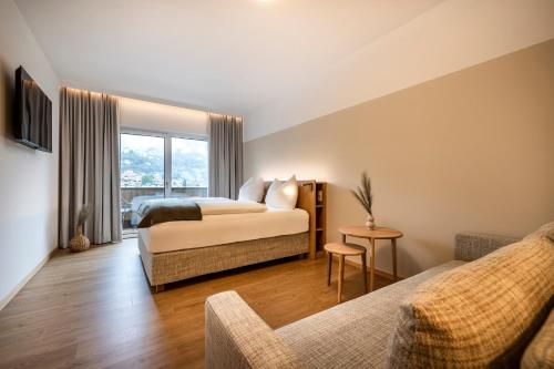 a bedroom with a bed and a couch at Hotel Hubertus in Sankt Johann im Pongau