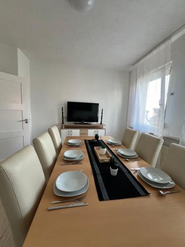 a room with a long table with chairs and a television at Stadtwohnung Trossingen Zentrum 5 Zimmer Maisonette in Trossingen