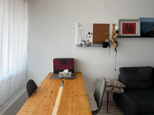 a dining room with a wooden table and a couch at Moderne 1-Zimmer Wohnung stadtnah in Neu Ulm
