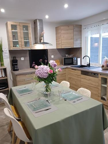 a kitchen with a table with a vase of flowers on it at Trégastel in Trégastel