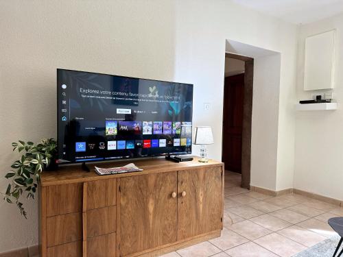 Une grande télévision à écran plat est installée au-dessus d'un meuble en bois. dans l'établissement Convenient Stay with Private Parking, Smart TV & Bike Trails Nearby, à Monswiller